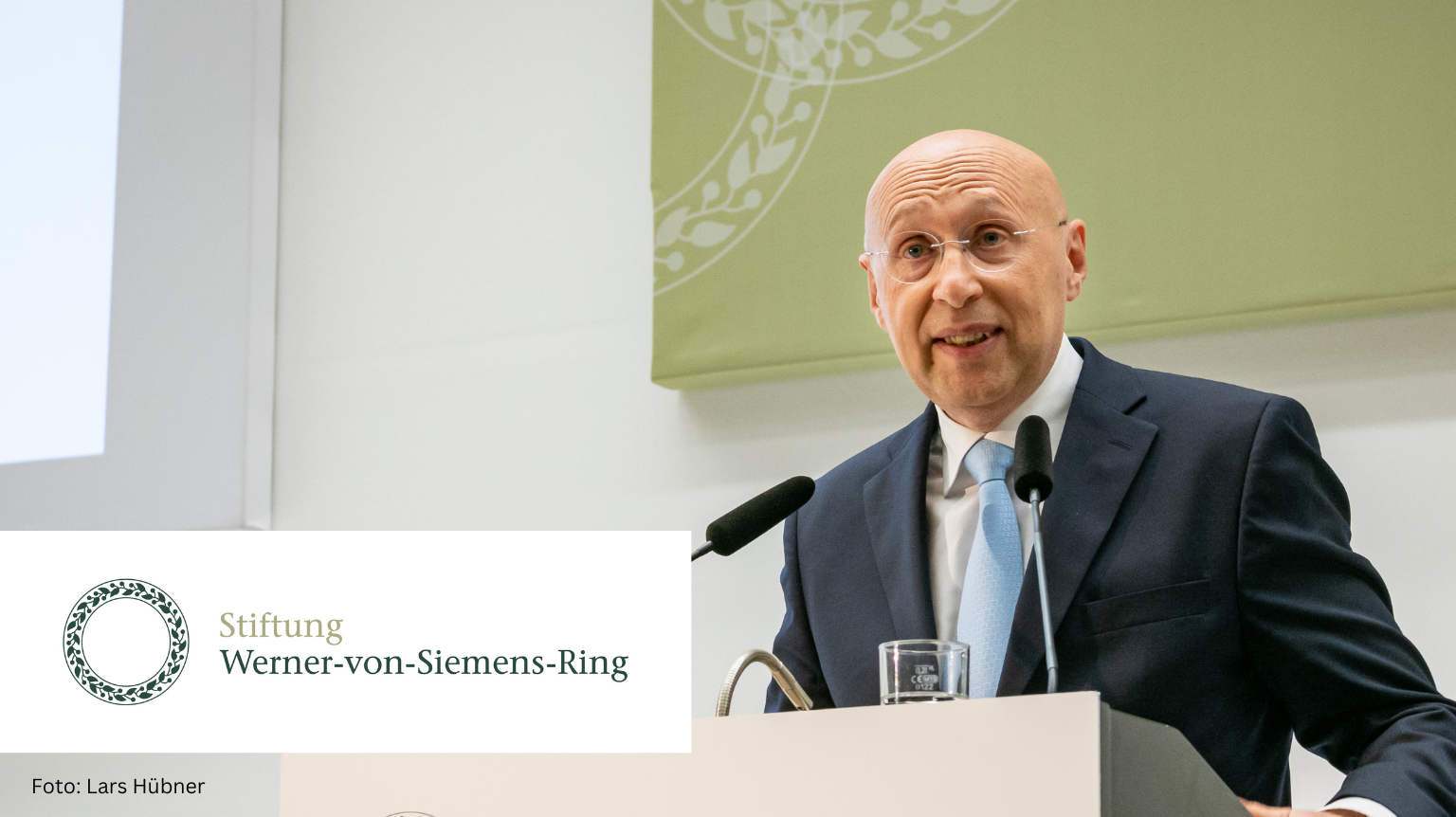 Foto von Stefan Hell am Rednerpult zur Verleihung des 40. und 41. Werner-von-Siemens-Rings 2022. Links unten die Wort- und Bildmarke der Stiftung Werner-von-Siemens-Ring