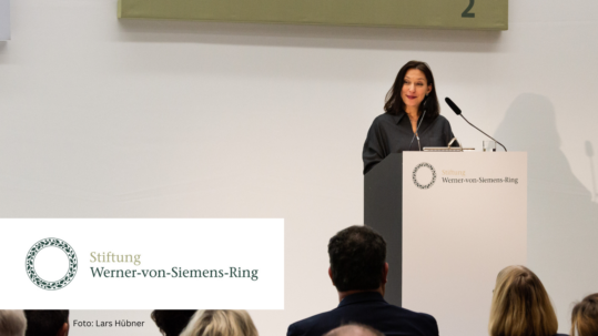 Foto von Nathalie von Siemens am Rednerpult zur Verleihung des 40. und 41. Werner-von-Siemens-Rings 2022. Links unten die Wort- und Bildmarke der Stiftung Werner-von-Siemens-Ring