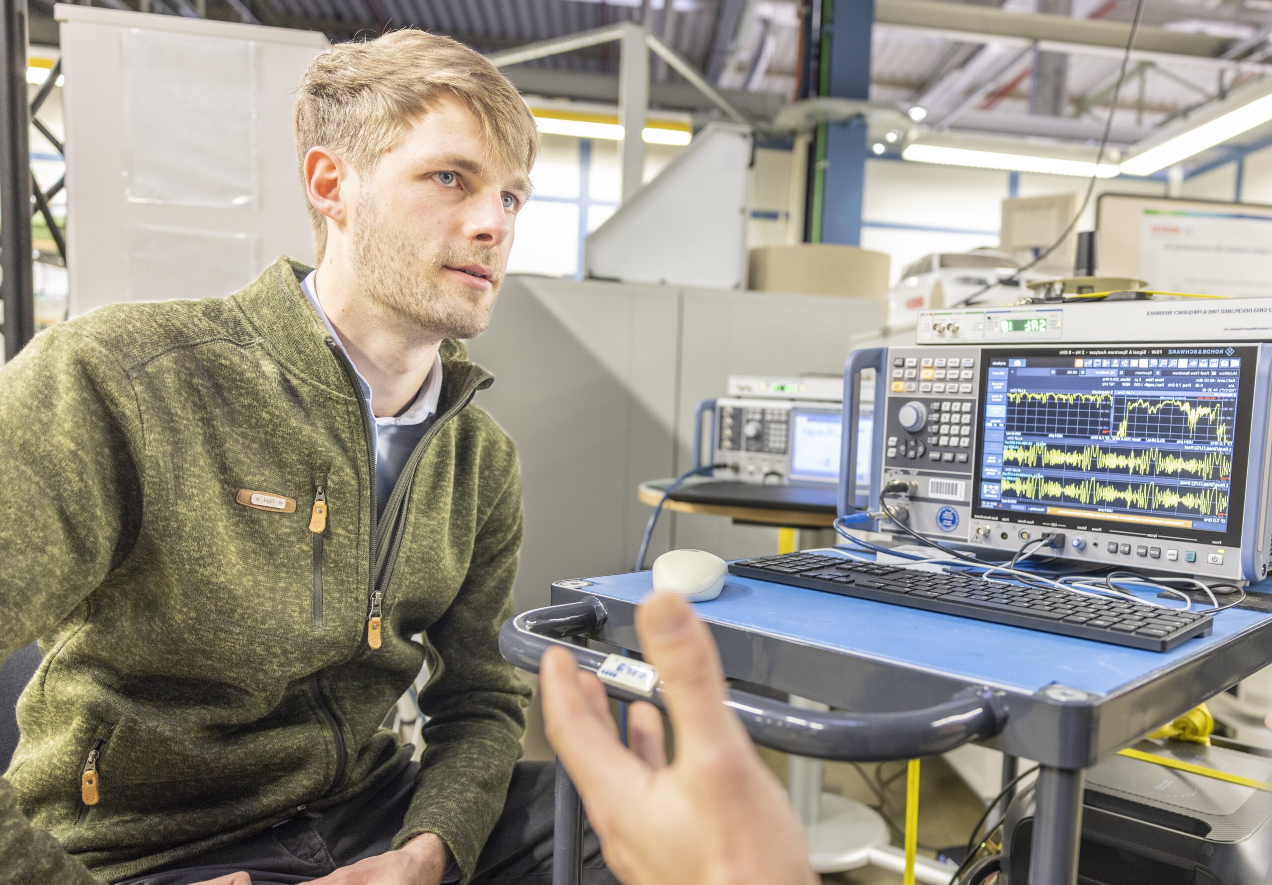 Portraitfoto von Florian Schiegg neben einem Computerbildschirm