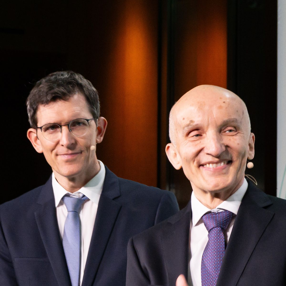 Portraitfoto von Michael Kösters (links) und Peter Kürz (rechts) auf der AXICA-Bühne.