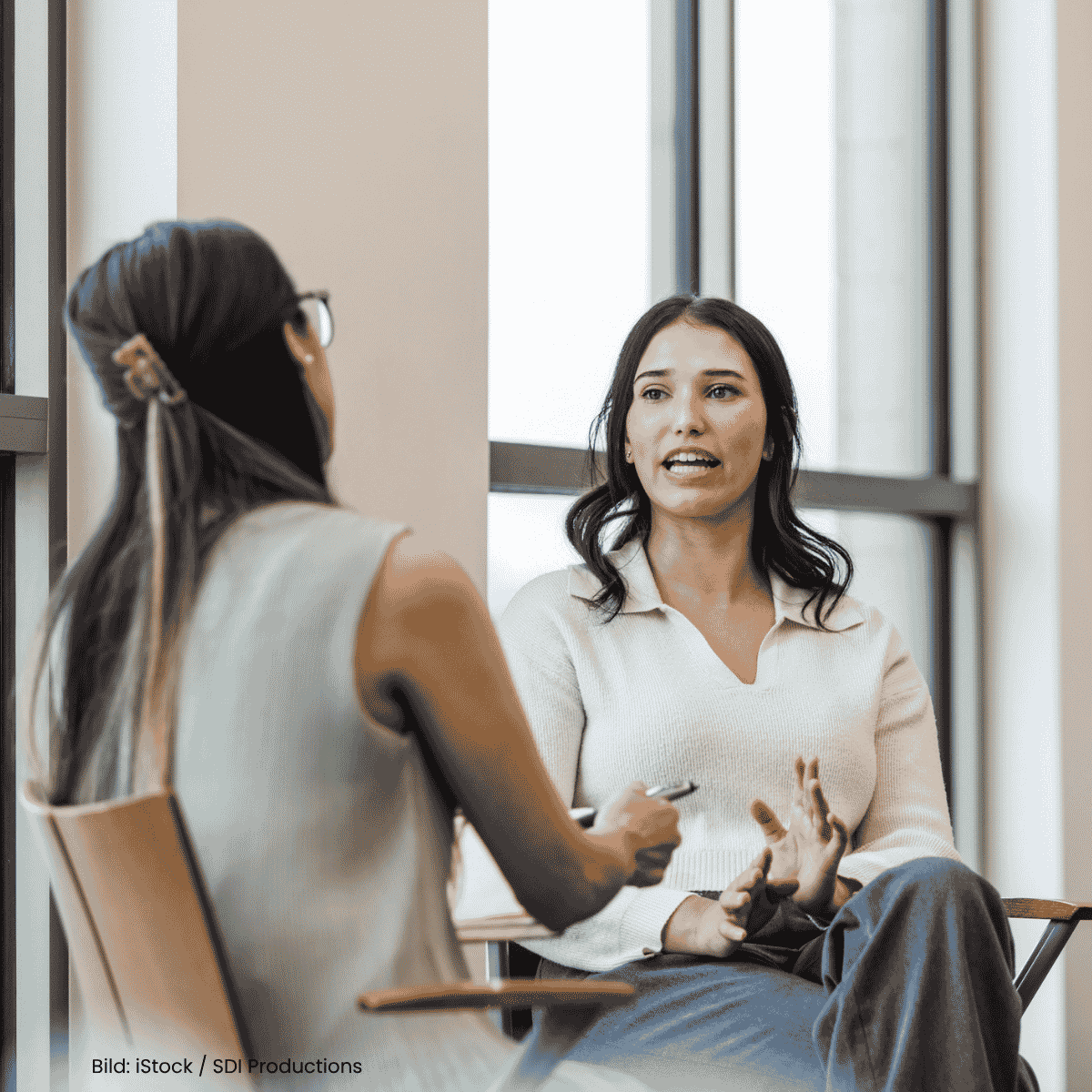 Foto zweier Frauen, die sich auf Stühlen gegenübersitzen unterhalten. Bild: iStock/SDI Productions